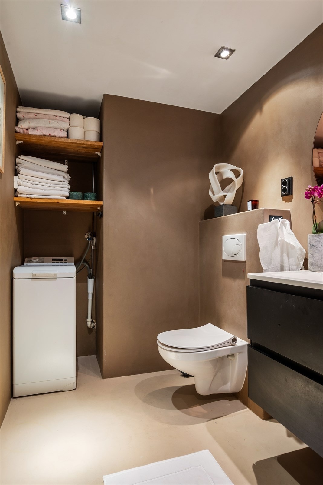 Veggfestet klosett med innebygget sisterne og opplegg for vaskemaskin. Galleribilde