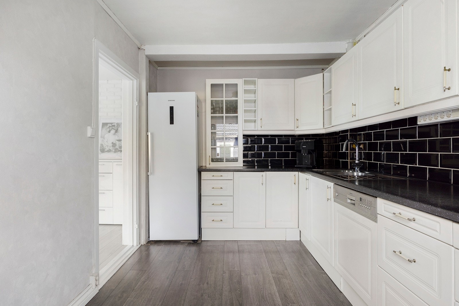 Separat kjøkken med profilert innredning, laminat benkeplate og fliser mellom benk og overskap. Galleribilde