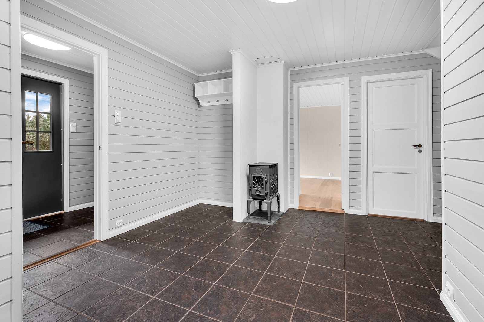 Innbydende entré og hall med flislagt gulv og vedovn som gir ekstra varme på kalde dager. Galleribilde