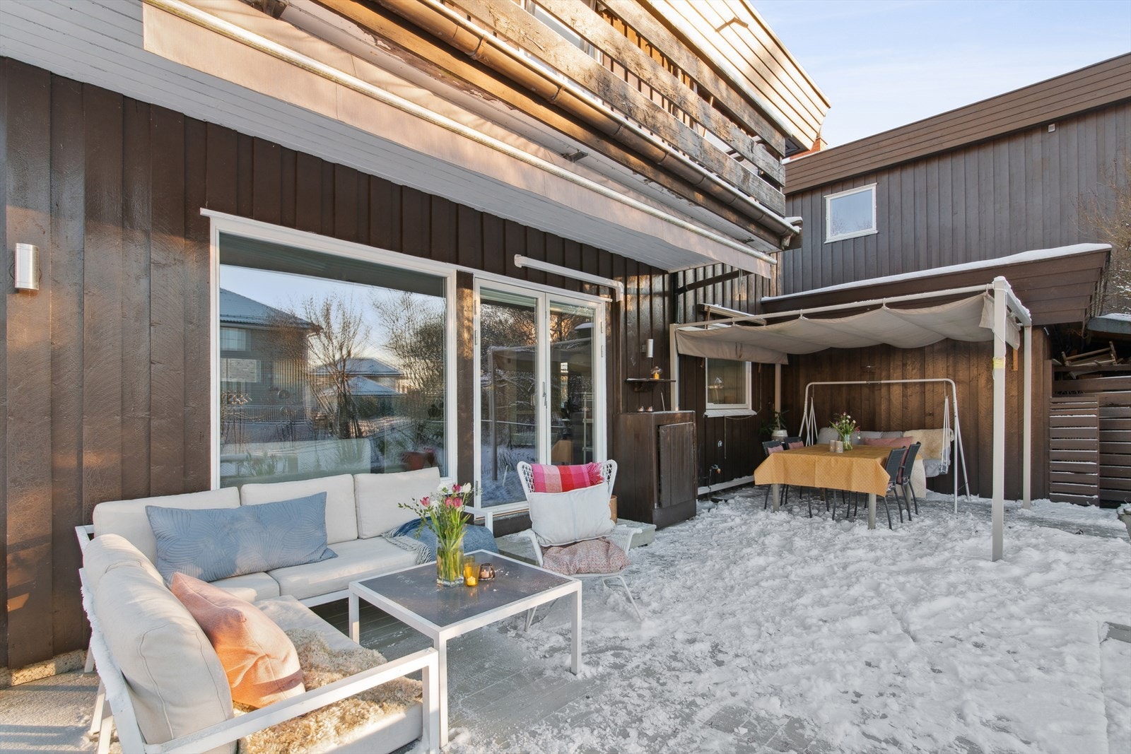 Stor solrik terrasse utenfor stue/spisetsue i 1. etasje med både markise og pergola Galleribilde
