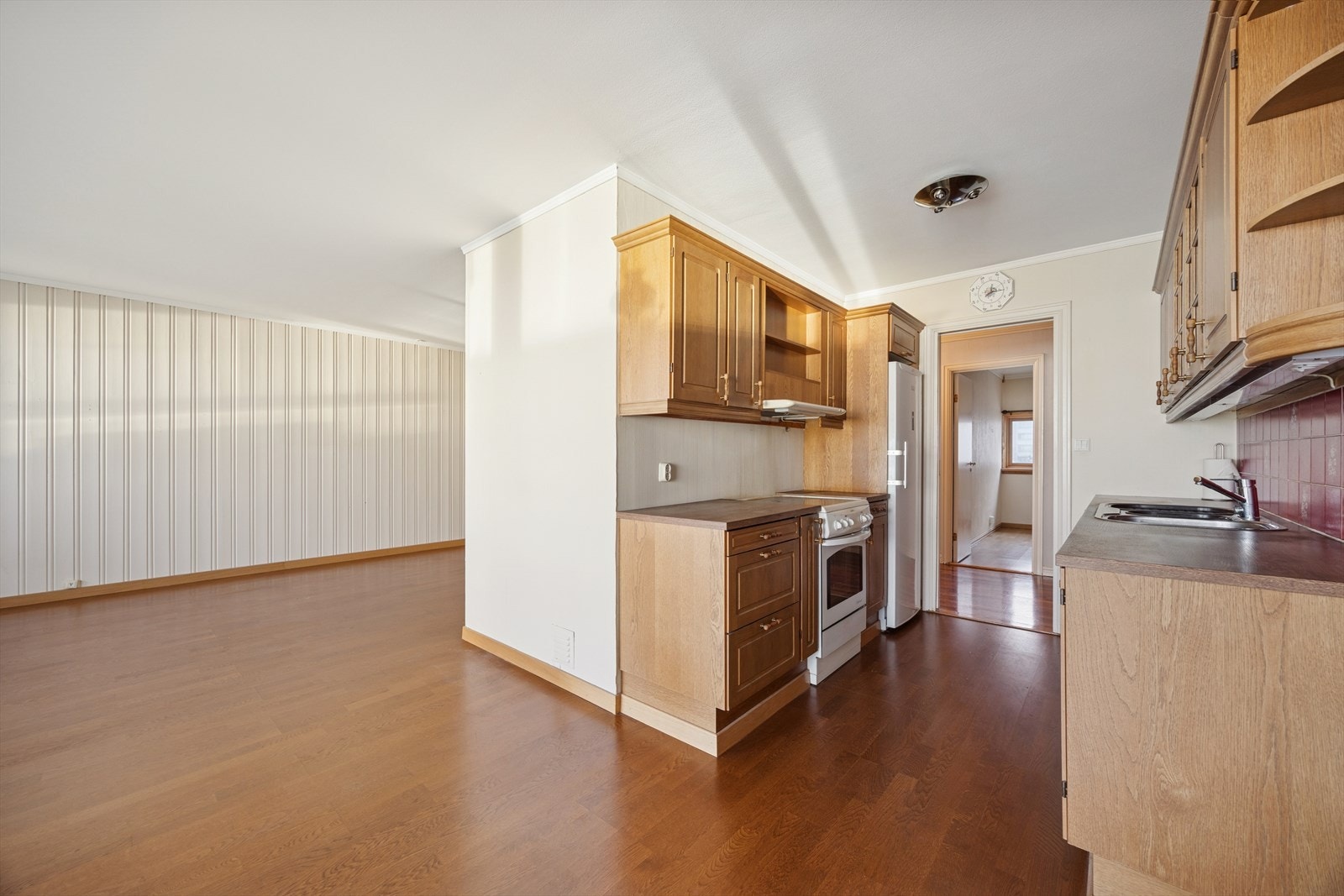 Kjøkkenet har eldre innredning med blant annet profilerte fronter i eikefinér og laminerte benkeplater i imitert tre. Galleribilde