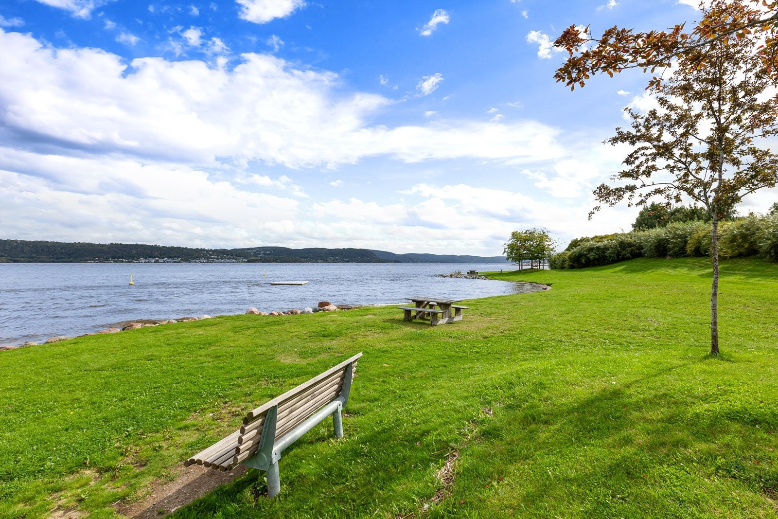 Sota har store gressarealer og sandstrand med badebrygge Galleribilde
