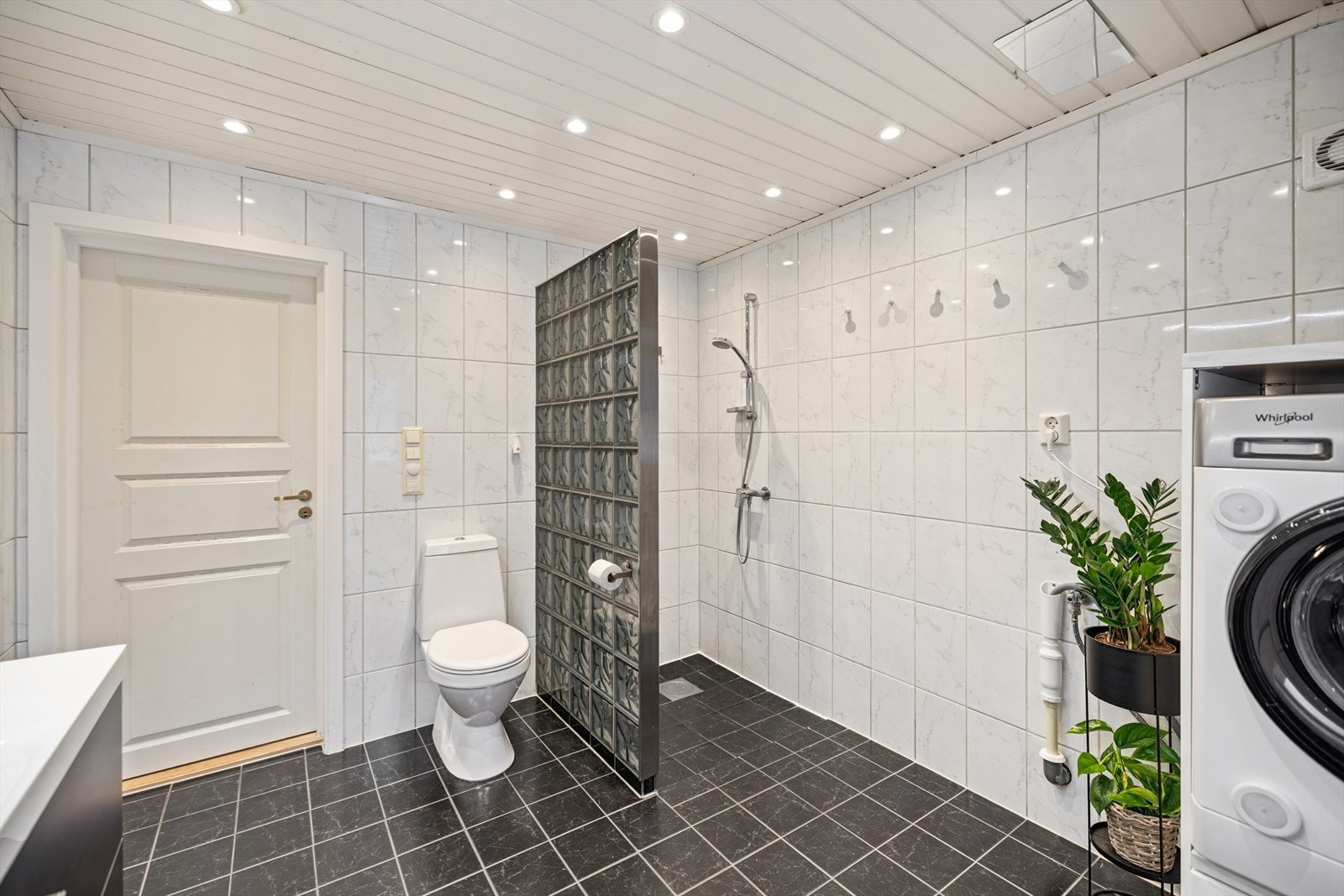 Rommet er innredet med toalett og en dusjnisje med vegg i glassbyggerstein. Galleribilde