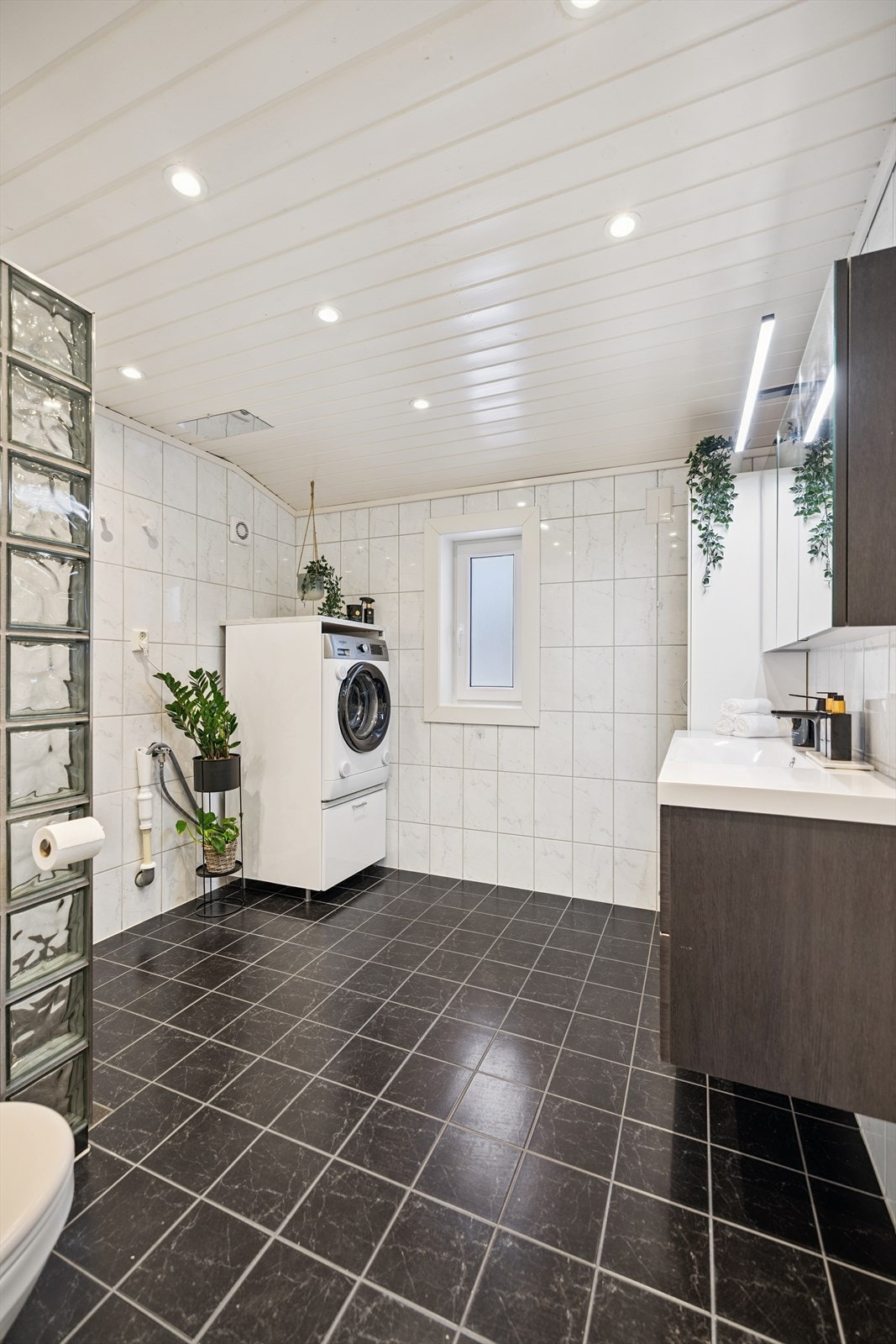 Her er det også praktisk opplegg for vaskemaskin, samt vegghengt servant med speilskap over. Galleribilde