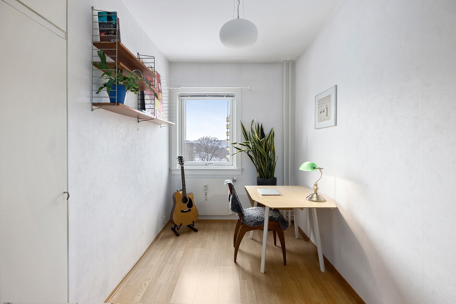 Leilighetens soverom 2, idag brukt som kontor, også med originalt plassbygde garderobeskap og pen utsikt fra vindu. Galleribilde