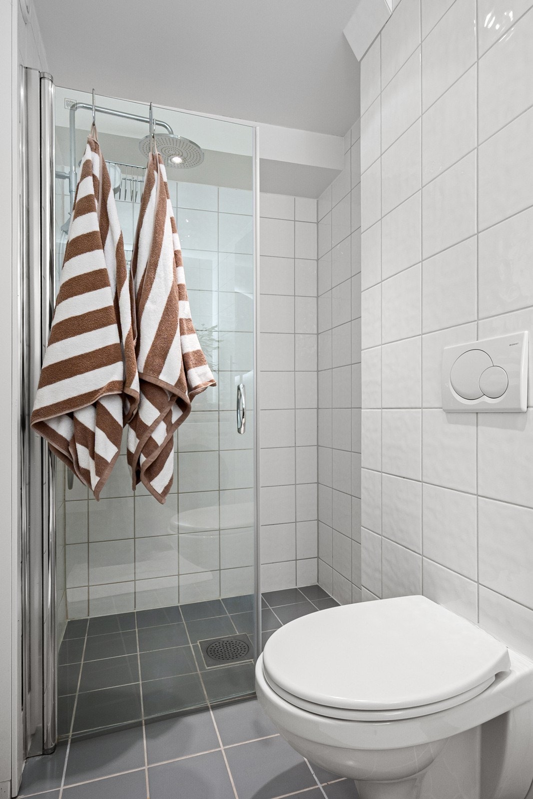 Rommet er innredet med servant med innredning, veggmontert toalett, dusjvegger/hjørneløsning samt opplegg for vaskemaskin. Galleribilde