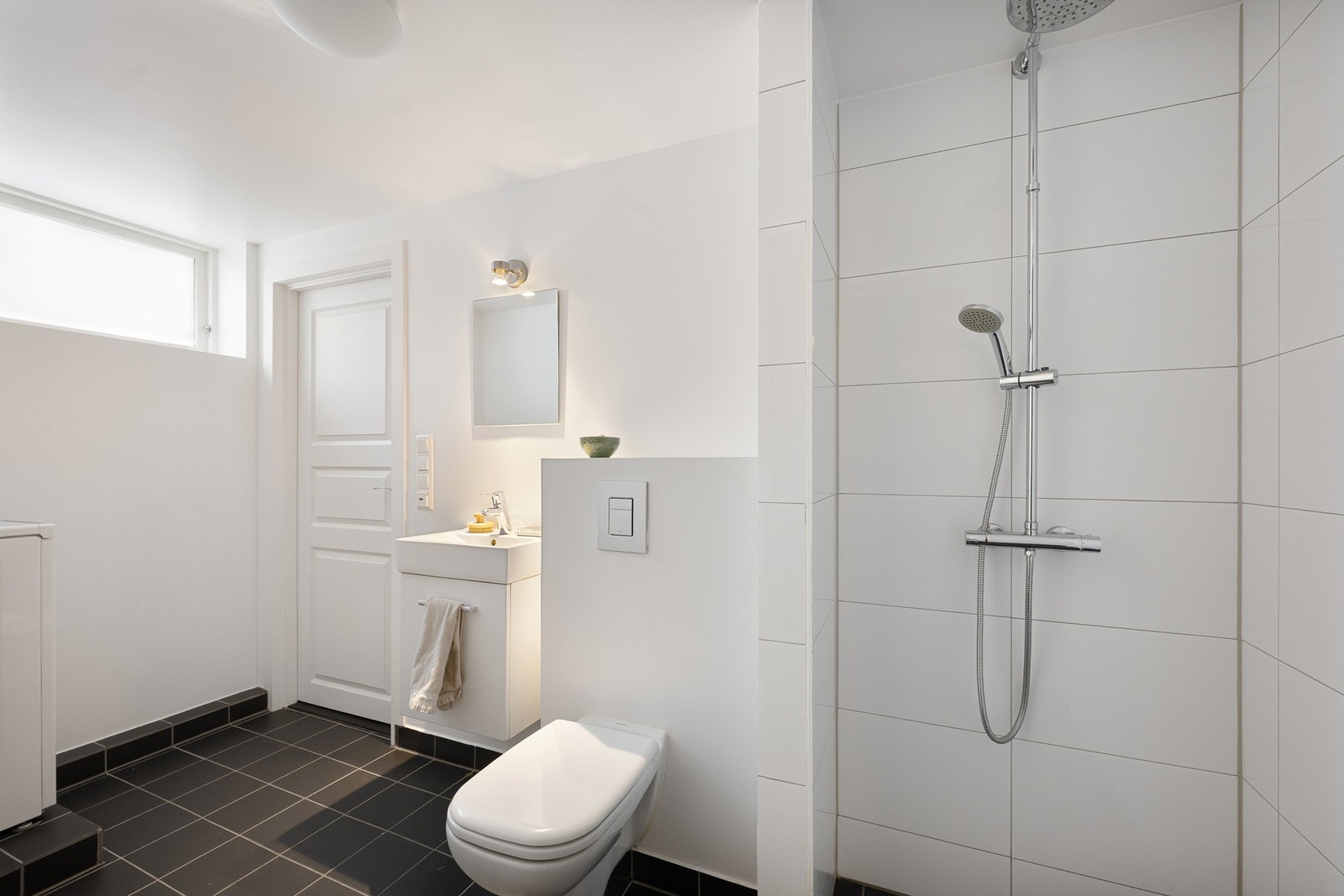 I underetasjen finnes det to baderom, begge med opplegg for vaskemaskin. Badet er innredet med servantskap med ovenpåliggende servant, vegghengt toalett og dusjnisje med regnfallsdusj og hånddusj. Galleribilde