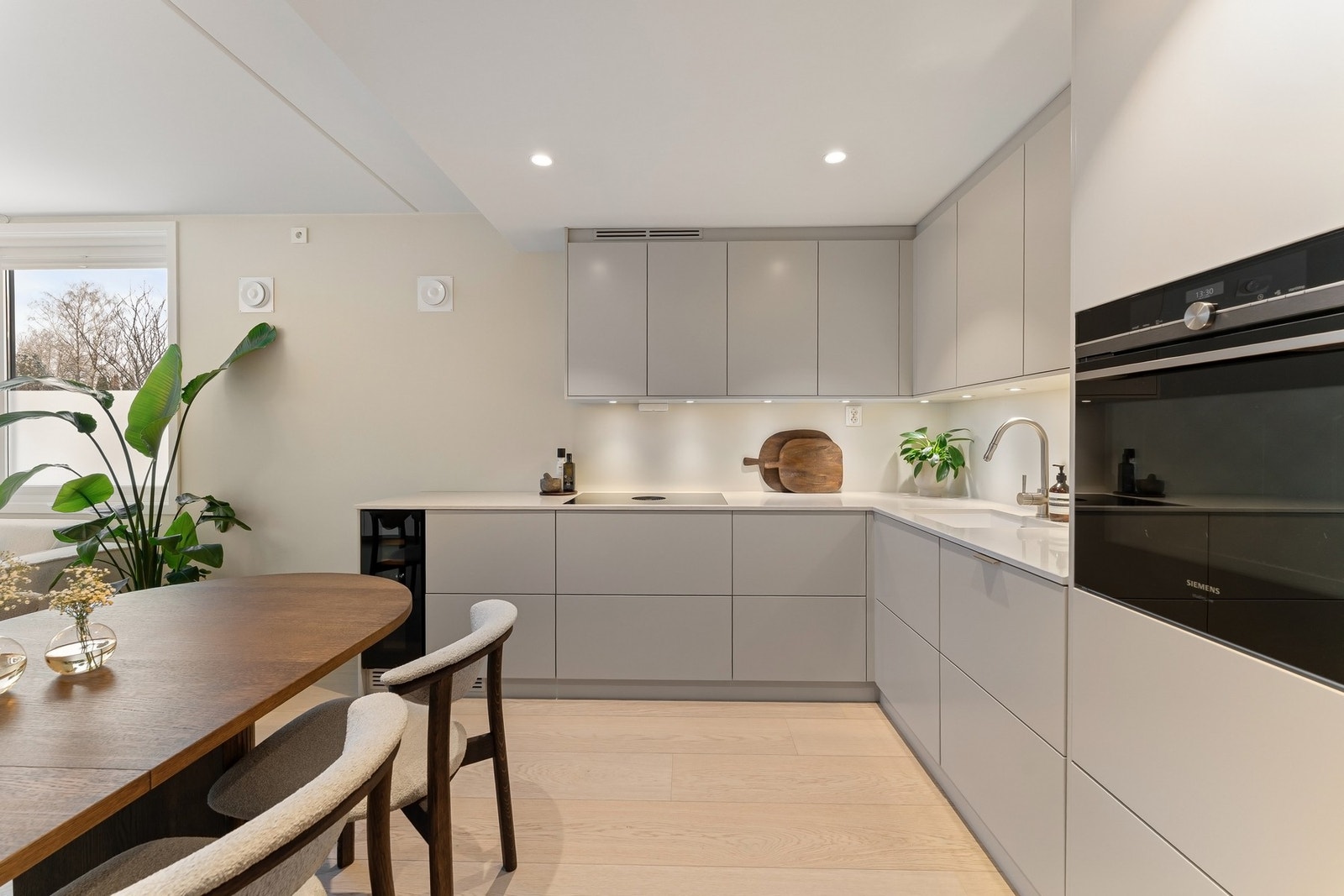 Takhøy kjøkkeninnredning med beige glatte fronter. Galleribilde