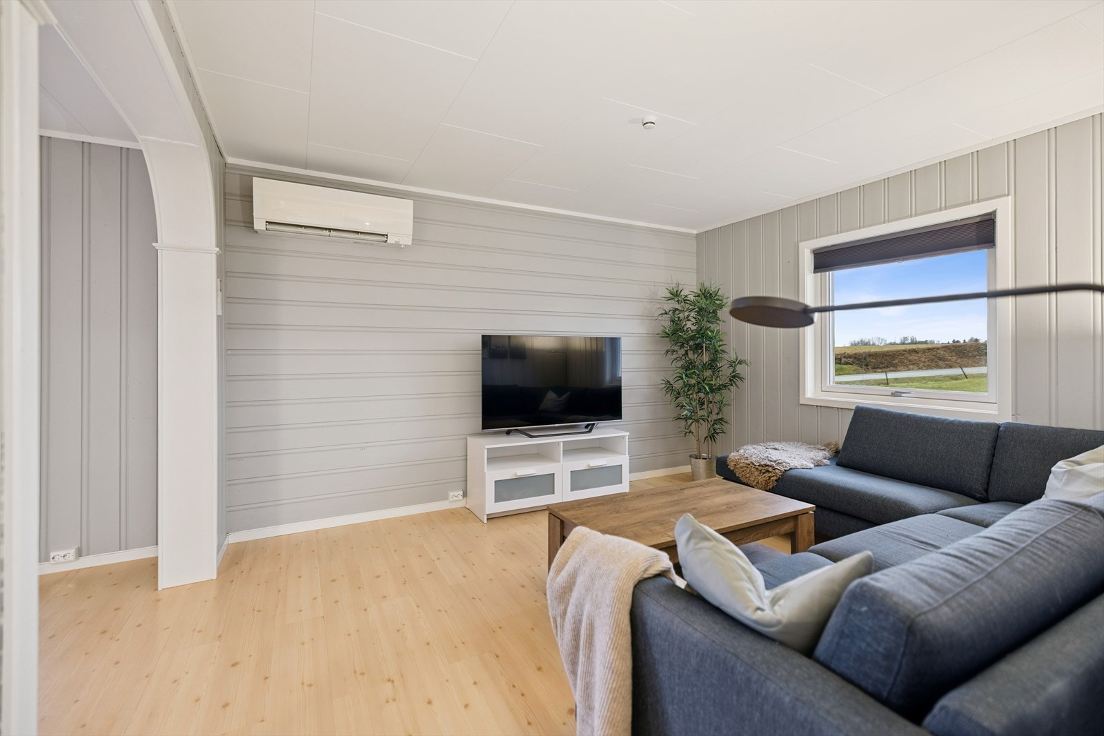 Stue med sittegruppe og vindu mot landlige omgivelser. Galleribilde