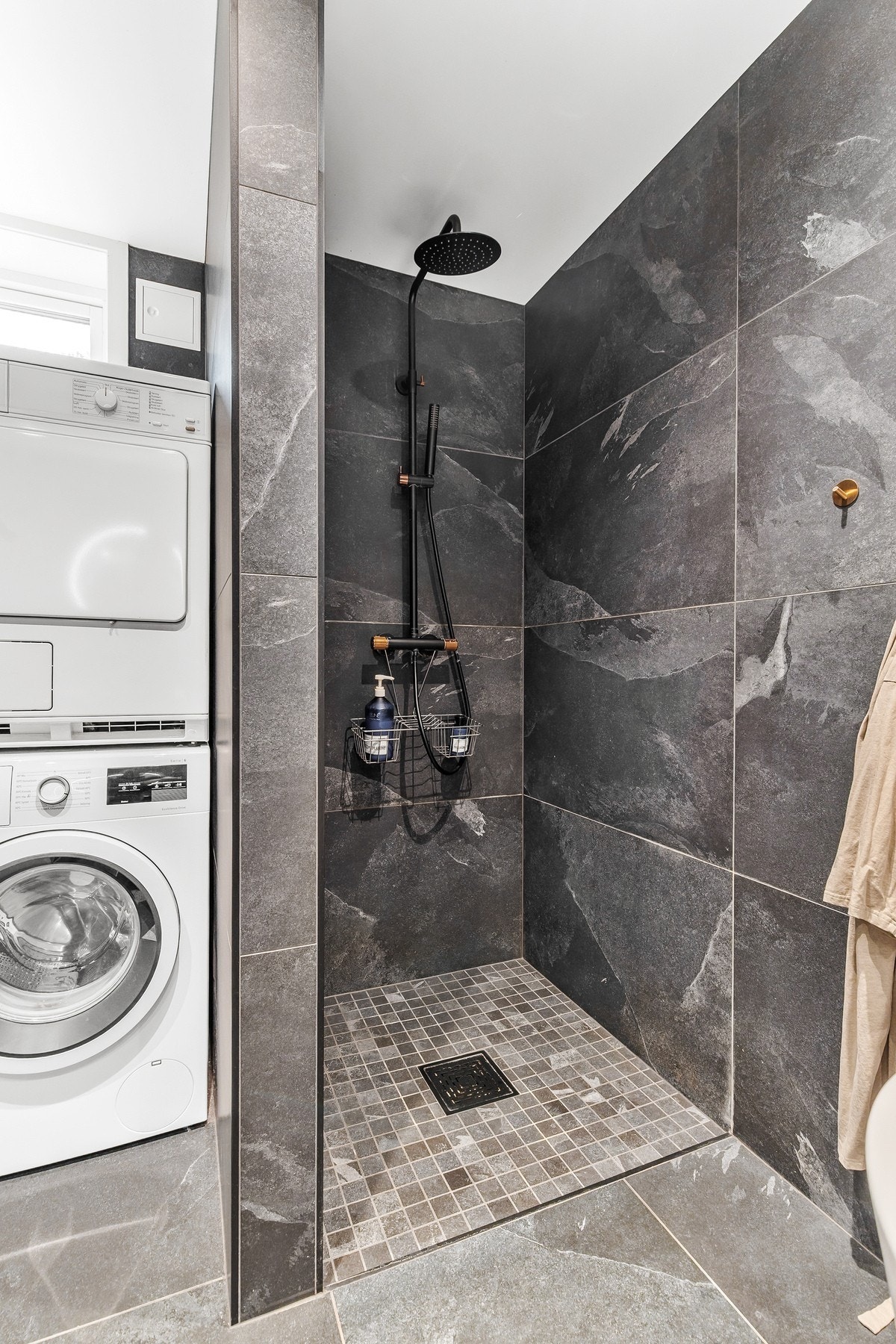 Videre er det etablert dusjnisje med svart dusjarmatur Galleribilde