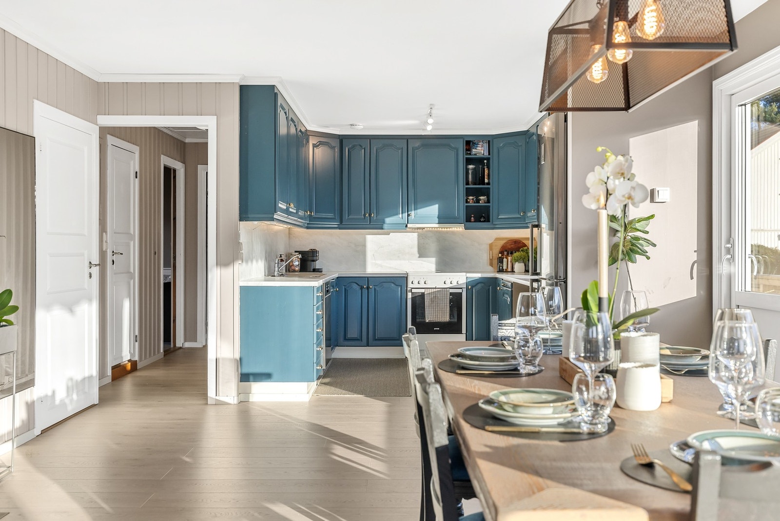 Kjøkkeninnredning med profilerte fronter, laminat benkeplate og nedfelt stålvask med ettgreps blandebatteri Galleribilde