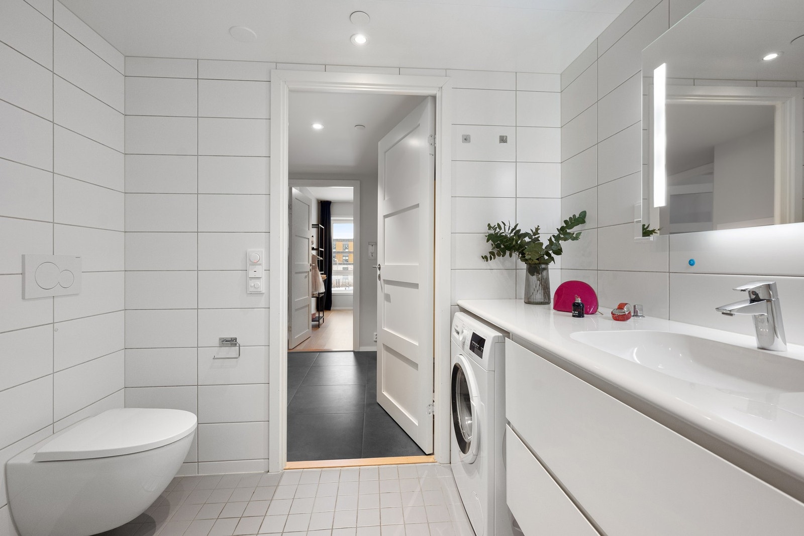 Stort bad med opplegg for vaskemaskin, med ankomst fra gang Galleribilde