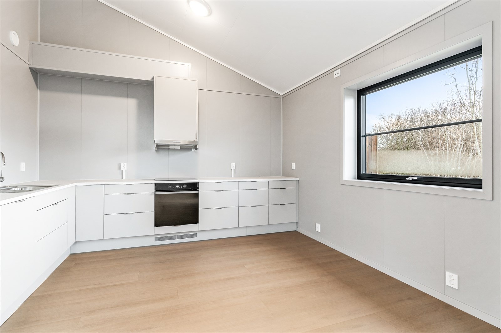 Kjøkkendelen er både funksjonell og estetisk tiltalende, med god plass til et lite spisebord der man kan nyte måltider eller samle venner til en hyggelig spillkveld. Galleribilde