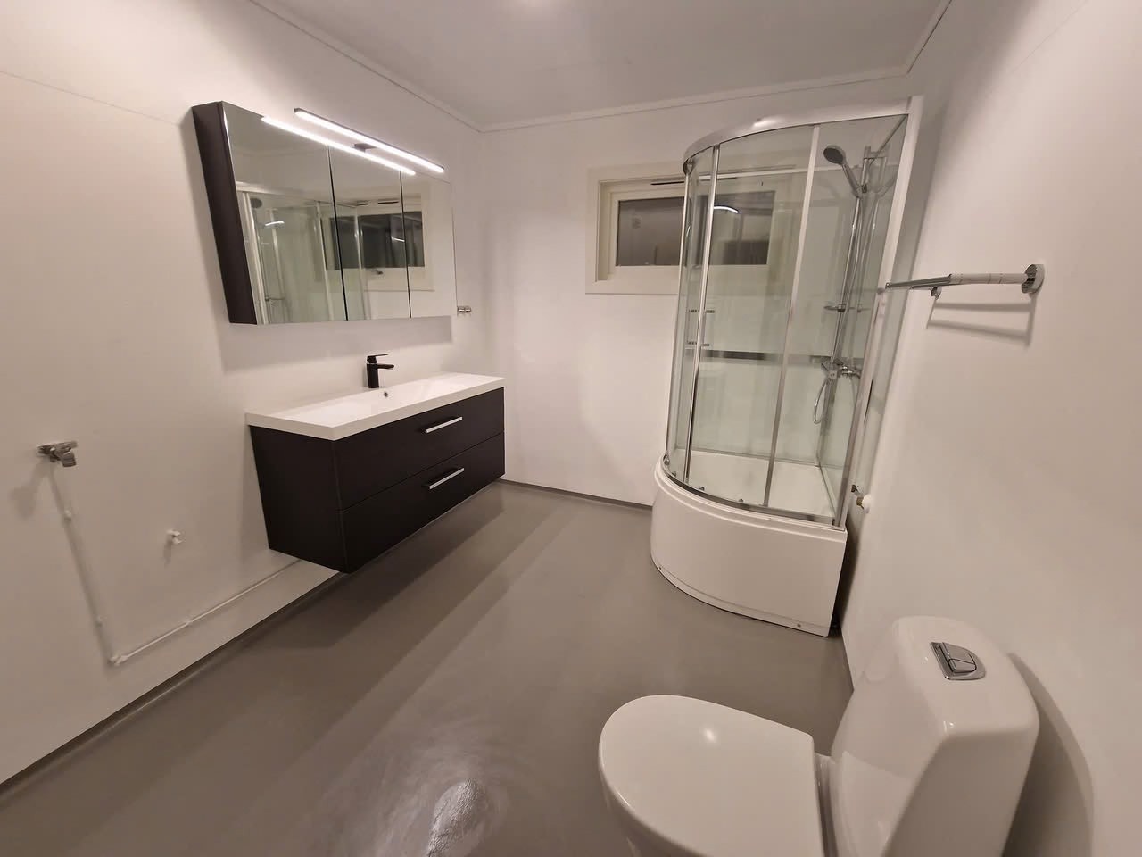 Oppusset bad med kabinett moderne innredning ig opplegg til vaskemaskin og tørketrommel. Galleribilde