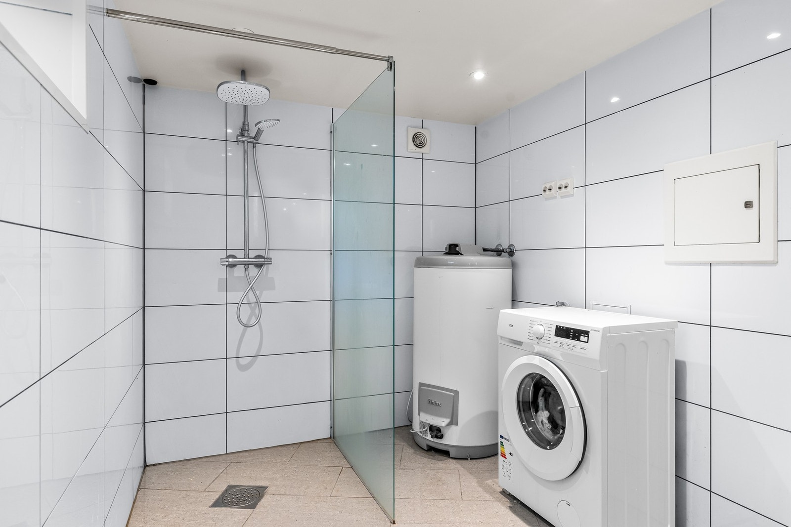 Bad med flislagte overflater og opplegg for vaskemaskin. Galleribilde