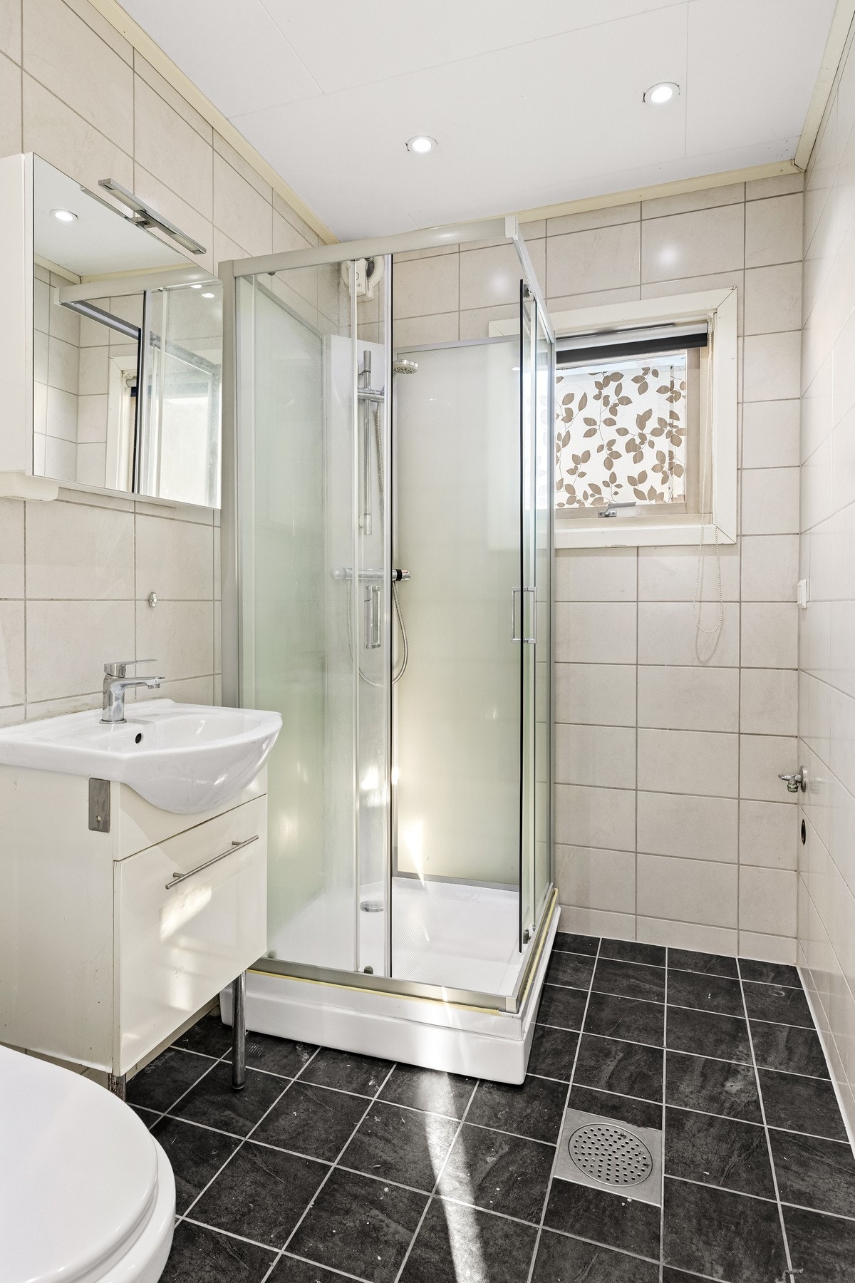 Bad med flislagte overflater og opplegg for vaskemaskin. Galleribilde