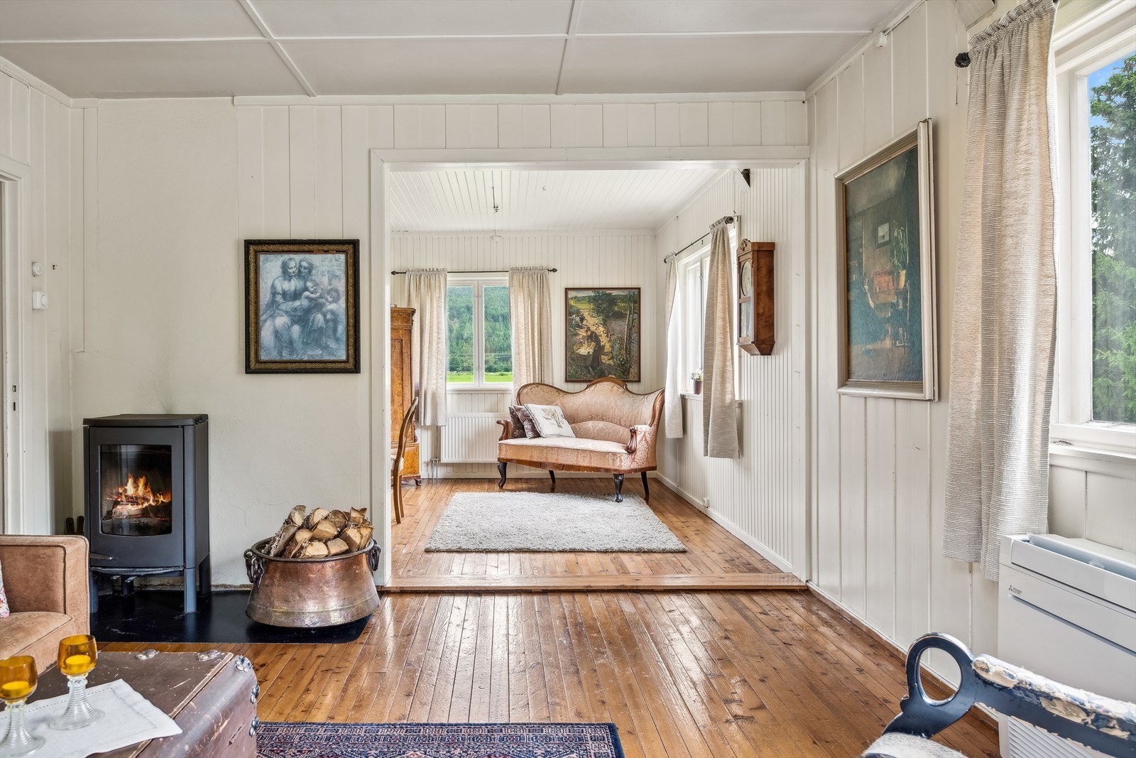 Stuen er delt i to soner. I den første delen står det en peisovn som gir godt med varme på de kalde dagene. Galleribilde