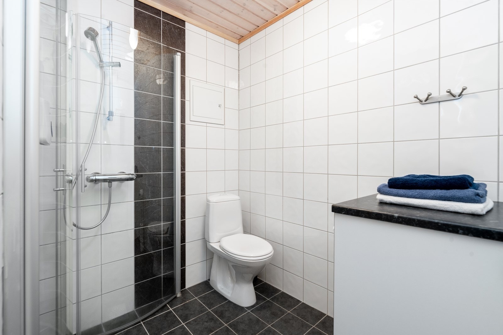 Det er i tillegg vegghengt skap og benk med varmtvannstanken under. Samt praktisk benk ved dusjhjørnet, med underskap for håndklær. Galleribilde