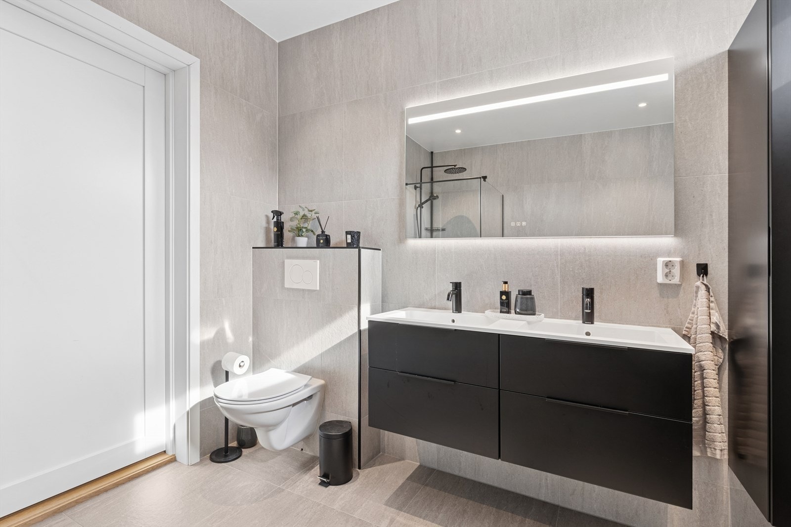 Alle vegger er flislagt fra gulv til tak med stilrene 60x60 cm grå fliser, som gir et elegant uttrykk. Galleribilde