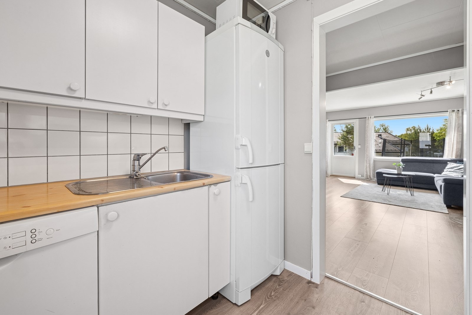 Lys kjøkkeninnredning med plass til frittstående hvitevarer. Galleribilde