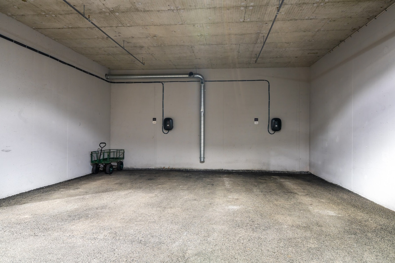 Parkeringsplass med elbil lader i garasjeanlegg. Galleribilde