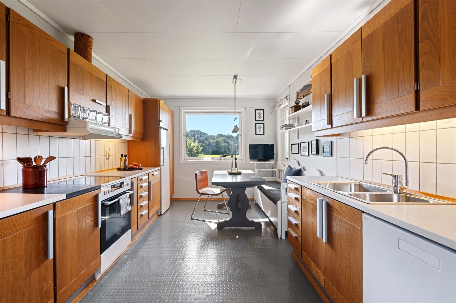 Kjøkkenet har en tidløs innredning med profilerte fronter og benkeplate i slitesterk laminat, som gir både stil og funksjonalitet. Galleribilde