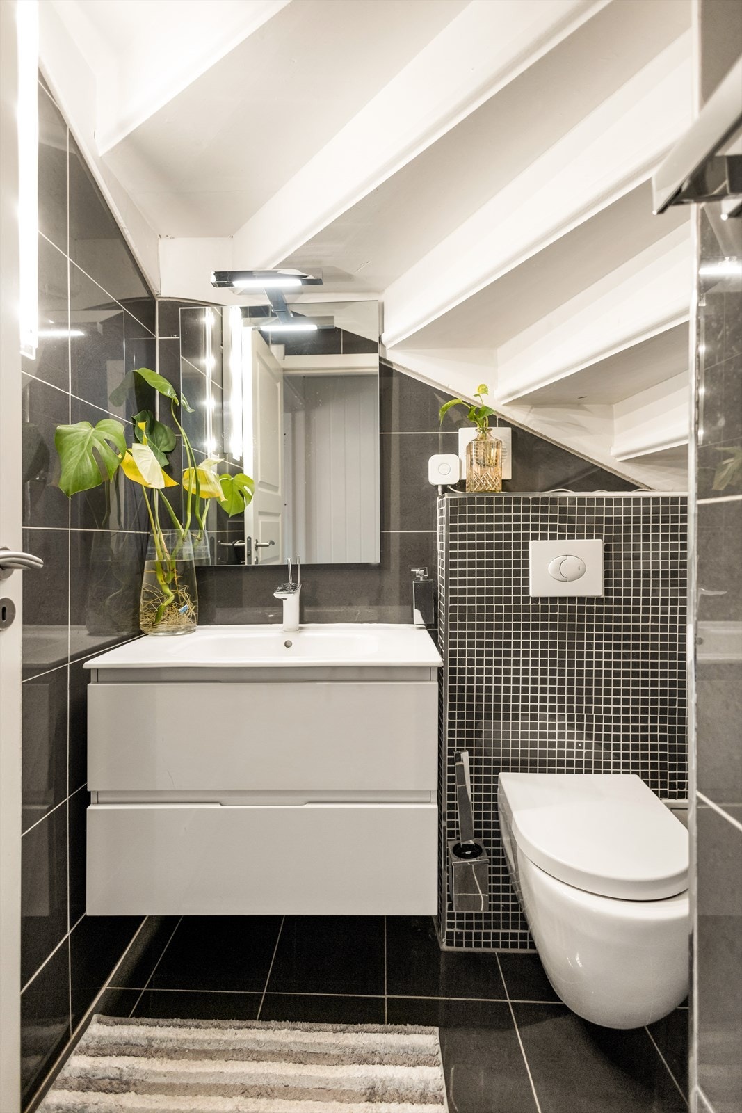 Praktisk toalettrom i første etasje, modernisert i 2018 med flislagte overflater og godt med plass til oppbevaring. Galleribilde