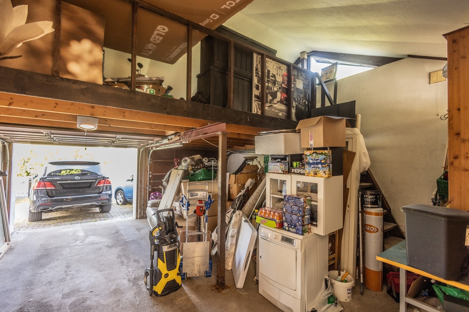 Garasjen har god plass til bil og oppbevaring, med en praktisk mesanin for ekstra lagring. Galleribilde