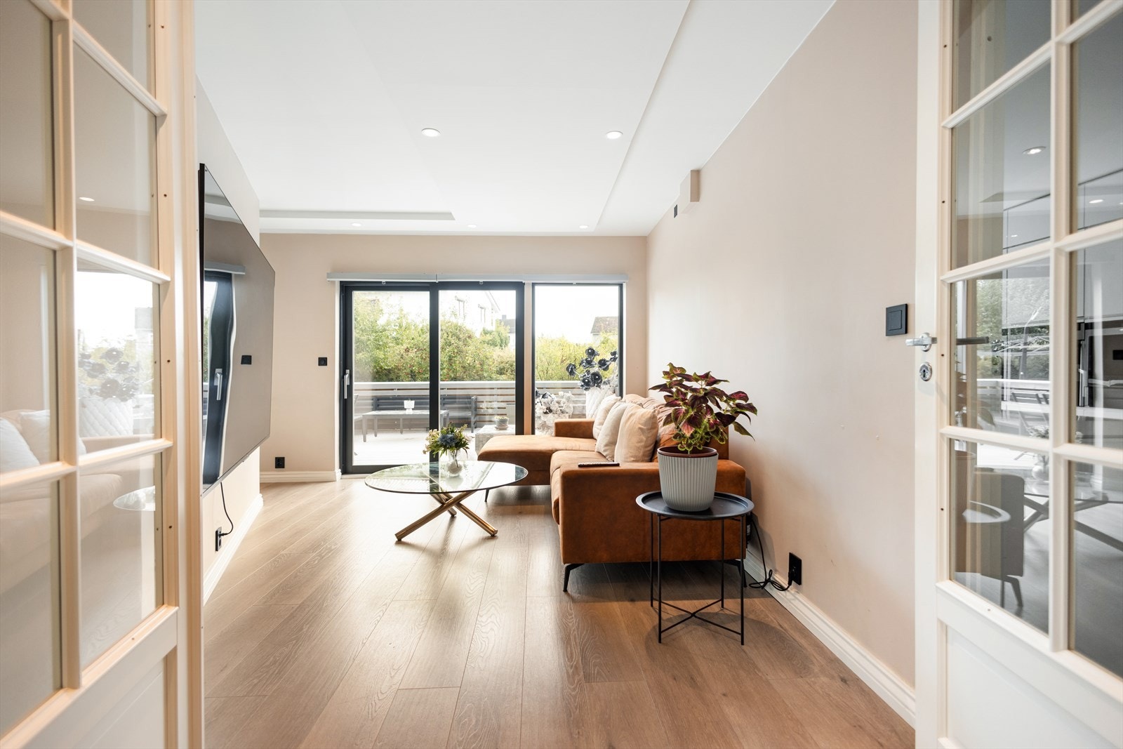 Doble glassdører skiller TV-stuen fra gangen og slipper inn godt med lys. Galleribilde