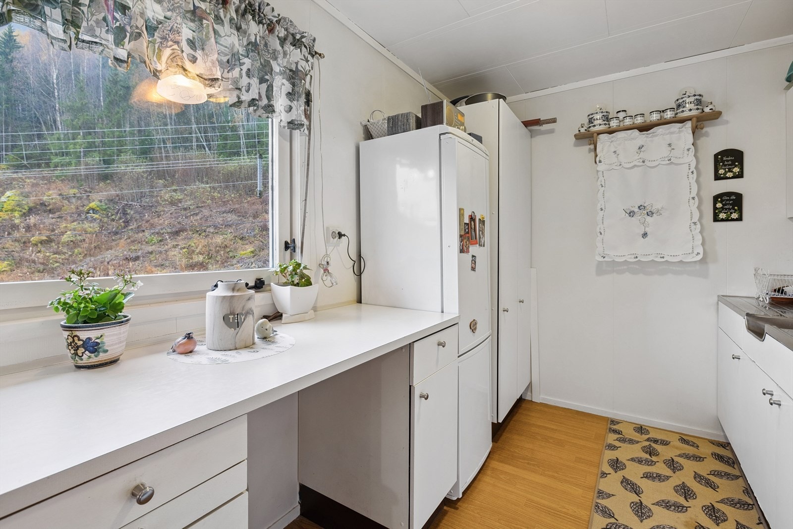 Her er det plass til frittstående hvitevarer, og et stort vindu over benken gir godt med arbeidslys. Galleribilde