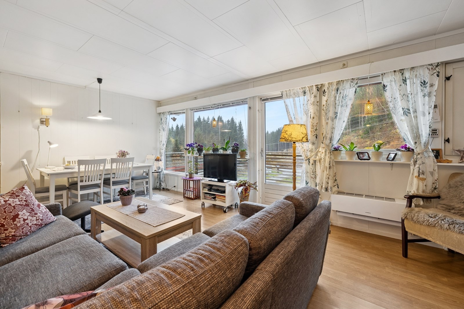 Stuen har plass til både sittegruppe og spisebord, med store vindusflater mot det vakre landskapet rundt eiendommen Galleribilde