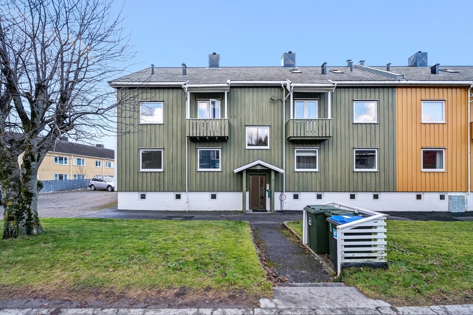 Fasade nord med felles hoved inngangsdør. Tomten er pent opparbeidet med gressplen og asfaltert gangareal. Galleribilde