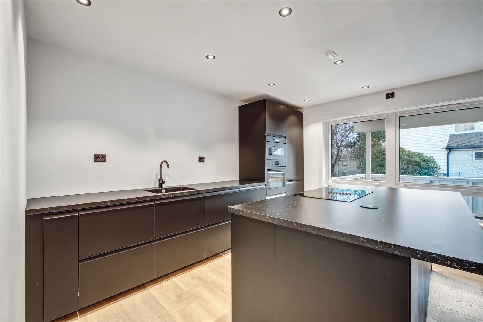 Mørke, glatte kjøkkenfronter gir en moderne og tidsriktig stil. Galleribilde