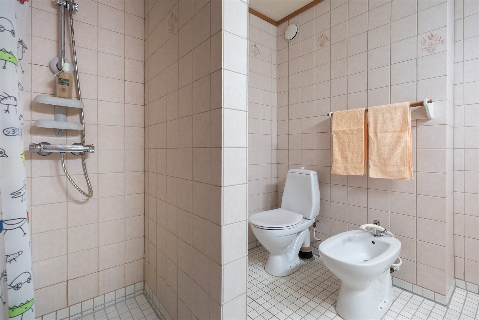 Varmekabler er installert, og den øvrige innredningen består av dobbel servant med hvite underskap, to matchende høyskap og et speil med tilhørende lys. Galleribilde