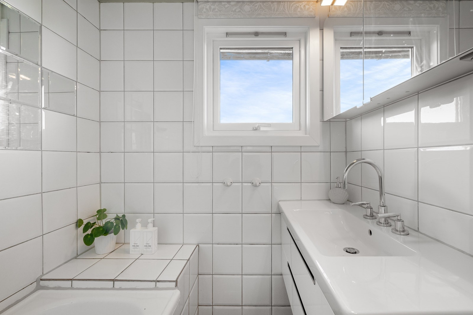 Badet er innredet med vegghengt servantskap med ovenpåliggende servant og to-greps armatur, speilskap med belysning, samt frittstående badekar med dusjarmatur og hånddusj. Galleribilde