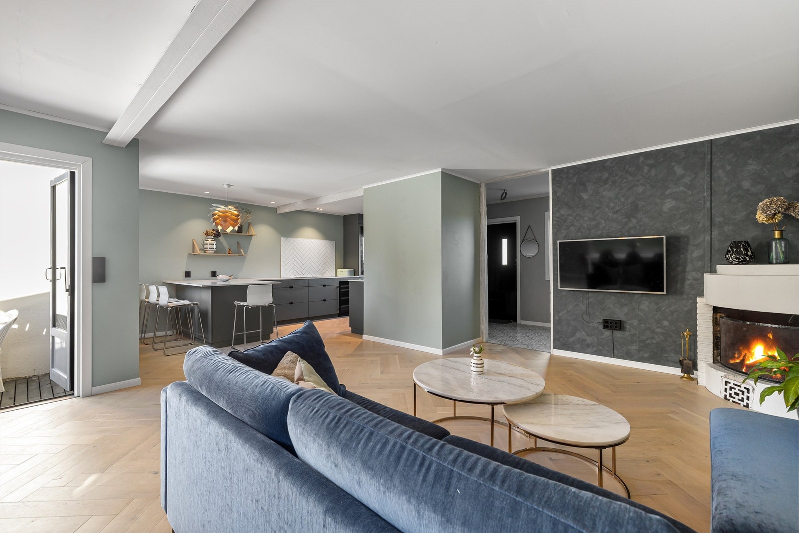 Overflatene i det store oppholdsrommet har parkett i elegant fiskebensmønster, malte vegger og himlinger med innfelte downlights. Galleribilde