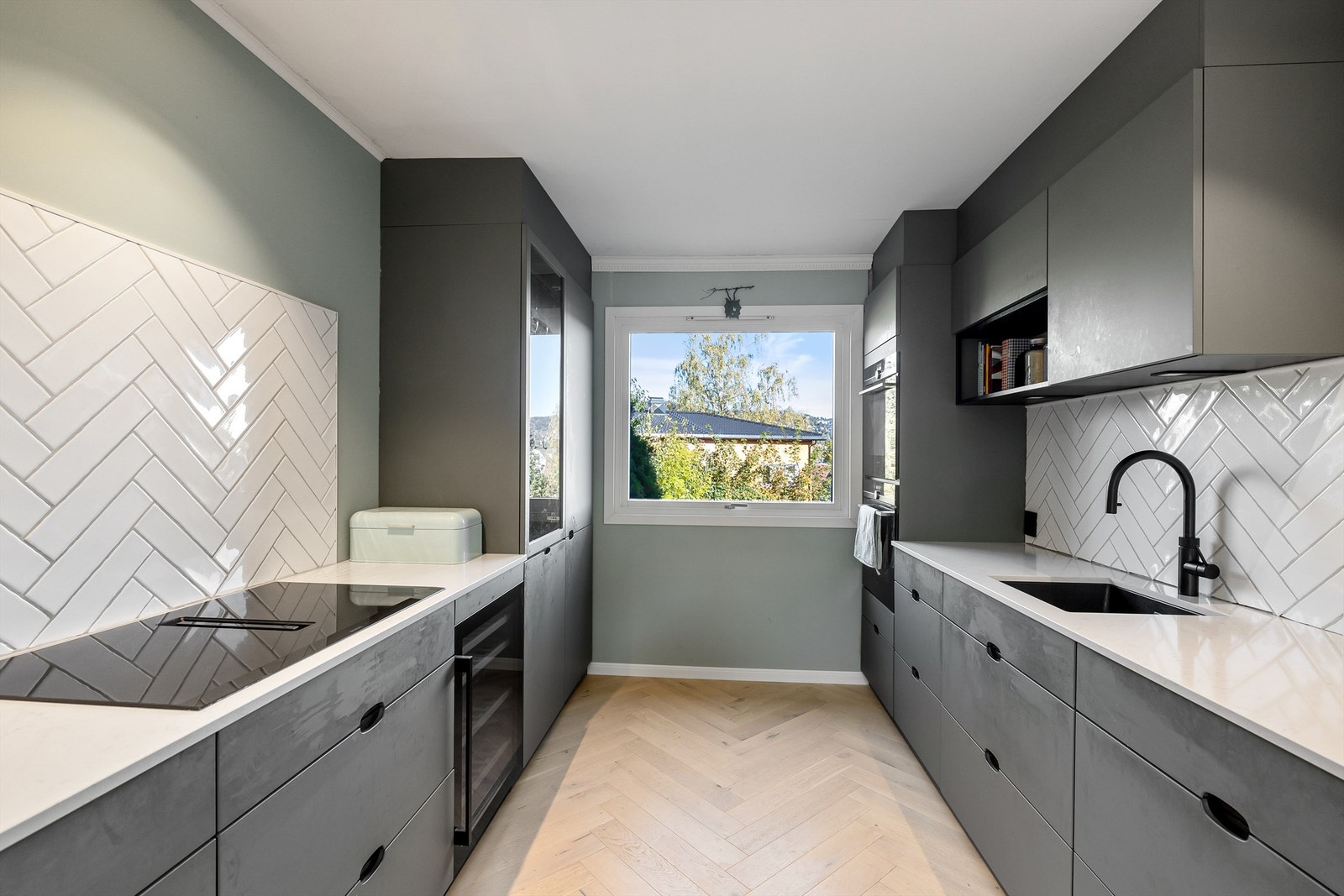 Benkeplate i stein gir et stilrent uttrykk, og den nedfelte oppvaskkummen med ettgreps armatur fra Quooker skaper en helhetlig finish. Galleribilde