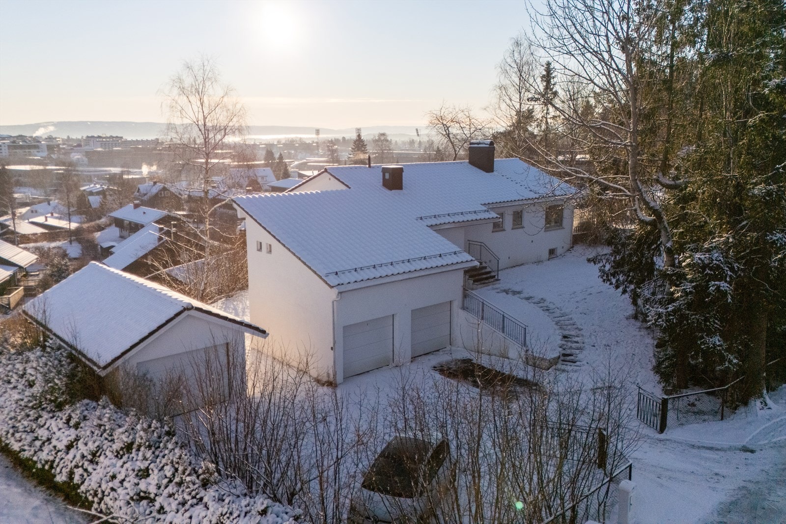 Stor opparbeidet gårdsplass med flere biloppstillingsplasser samt 3 garasjeplasser med elektriske porter og EL-billader Galleribilde