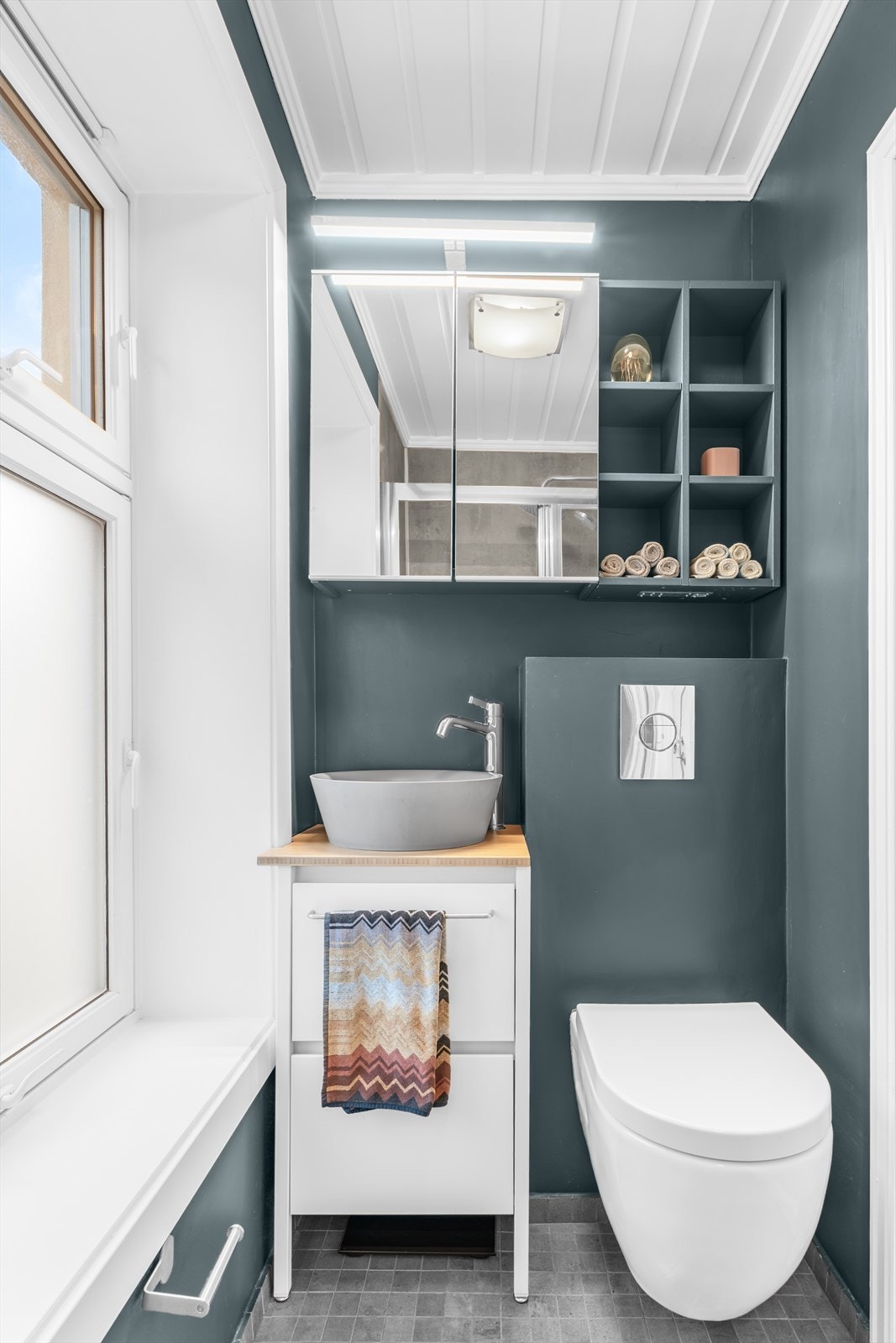 Vegghengt wc, servant med skuffer, hyller og speilskap med overhenget lys. Galleribilde