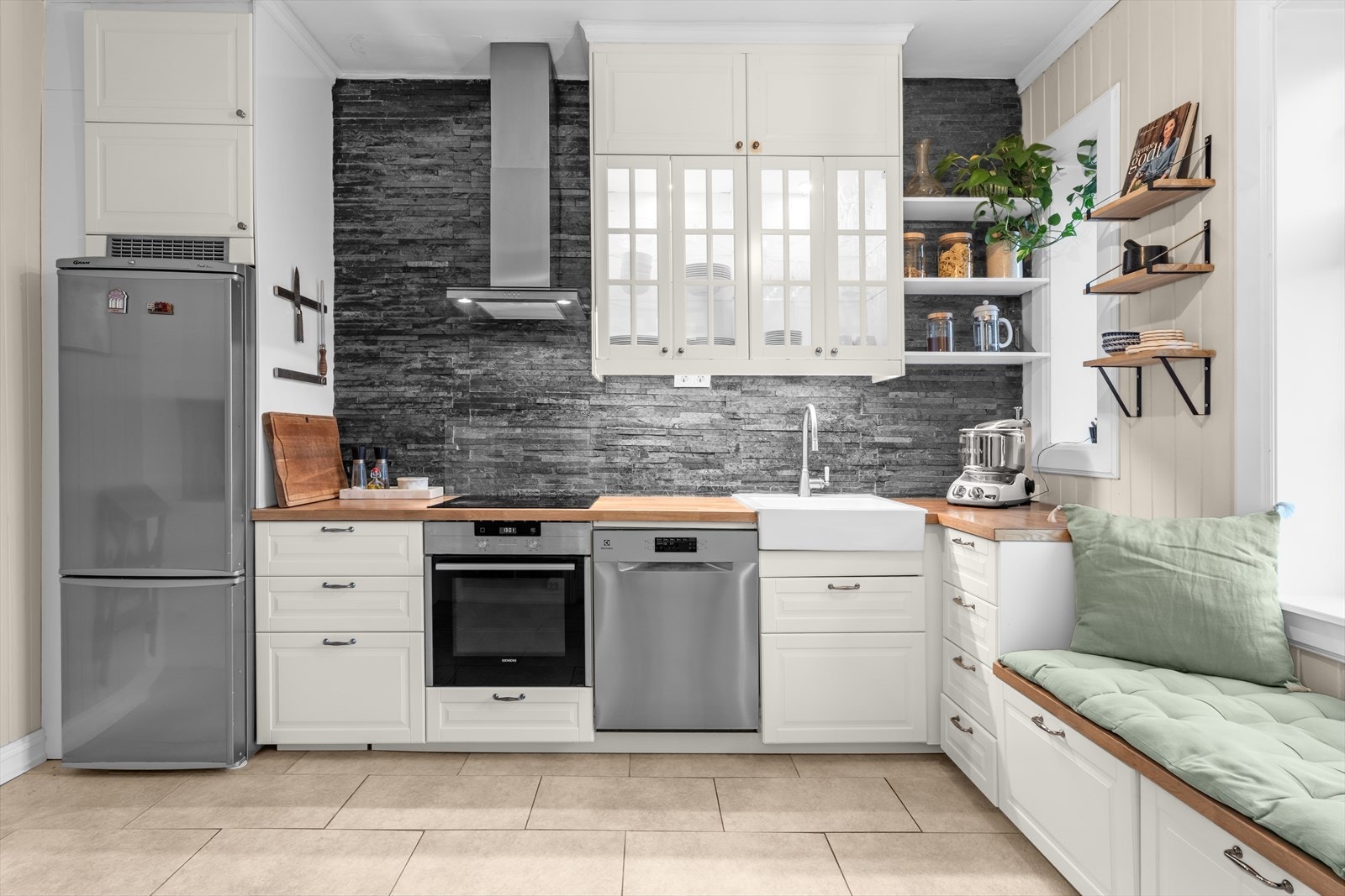 Detaljvegg med stavmosaikk i skifer bak kjøkkenet og sprutplate i glass bak platetoppen. Galleribilde