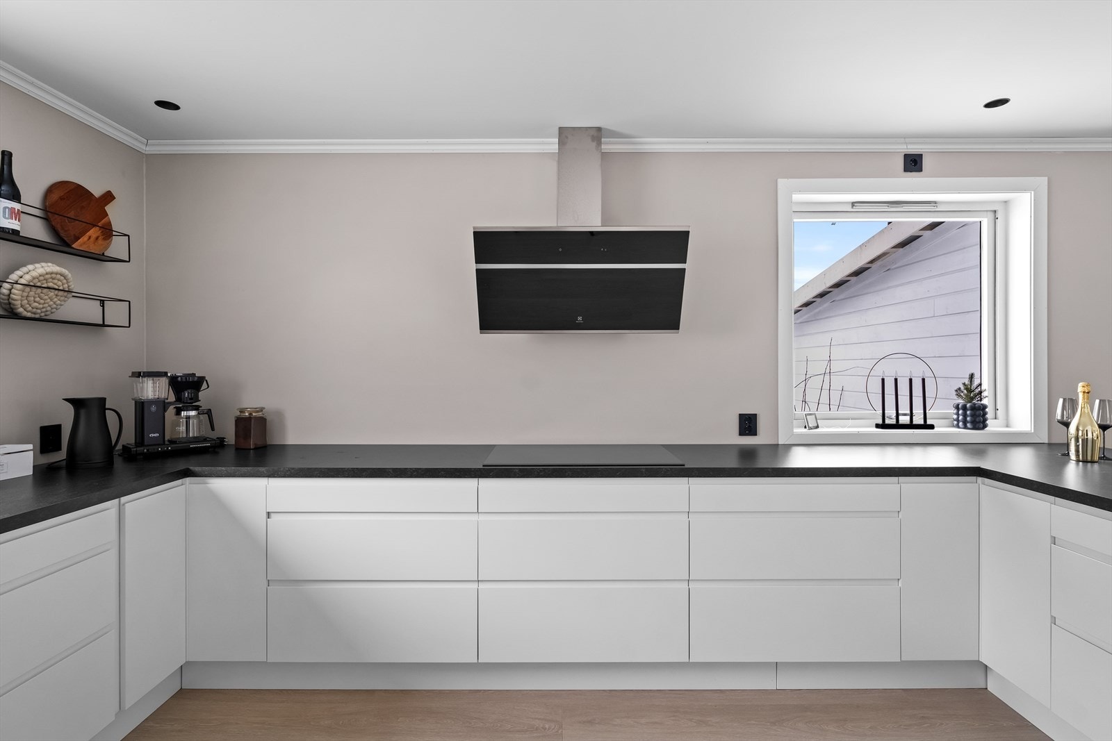 Hvite, glatte fronter, benkeplate i mørk laminat og gode vindusflater. Galleribilde