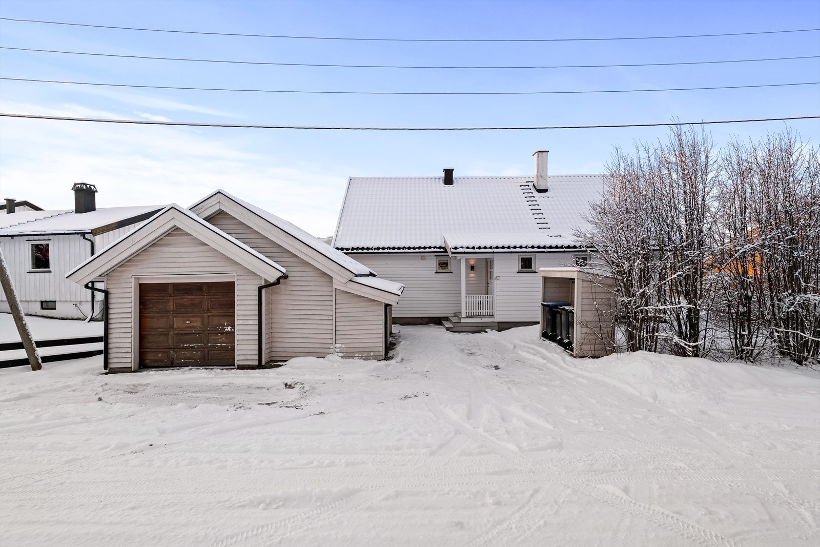 Parkering for en bil i garasje med tilliggende boder. Galleribilde