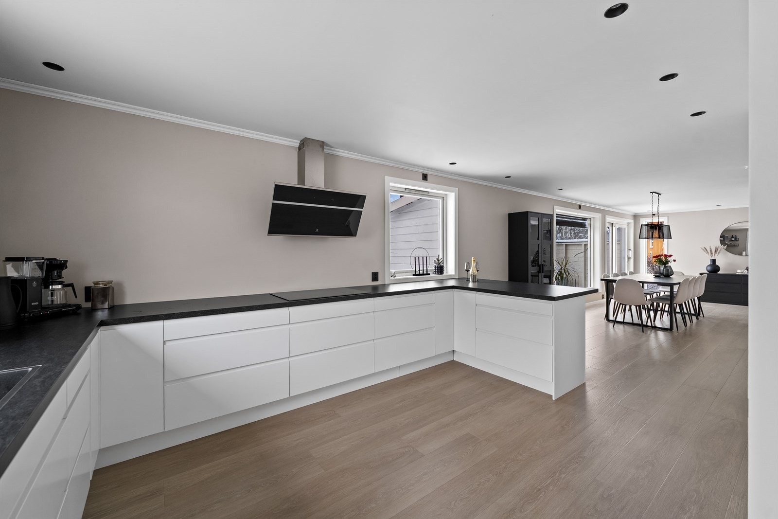 Kjøkkenet ligger i åpen løsning mot spisestuen - Samtidig som den forlengede benkeplaten gir et naturlig skille. Galleribilde