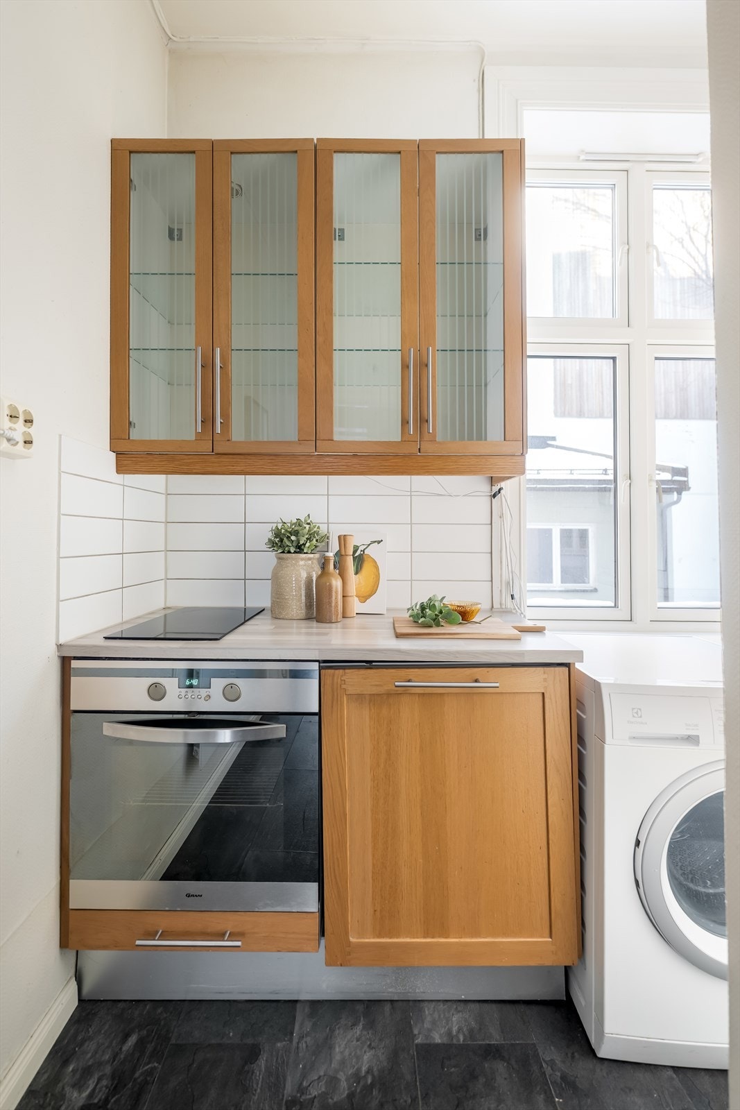 Funksjonelt kjøkken av eldre dato med glatte, lakkerte og finerte skapfronter. Galleribilde