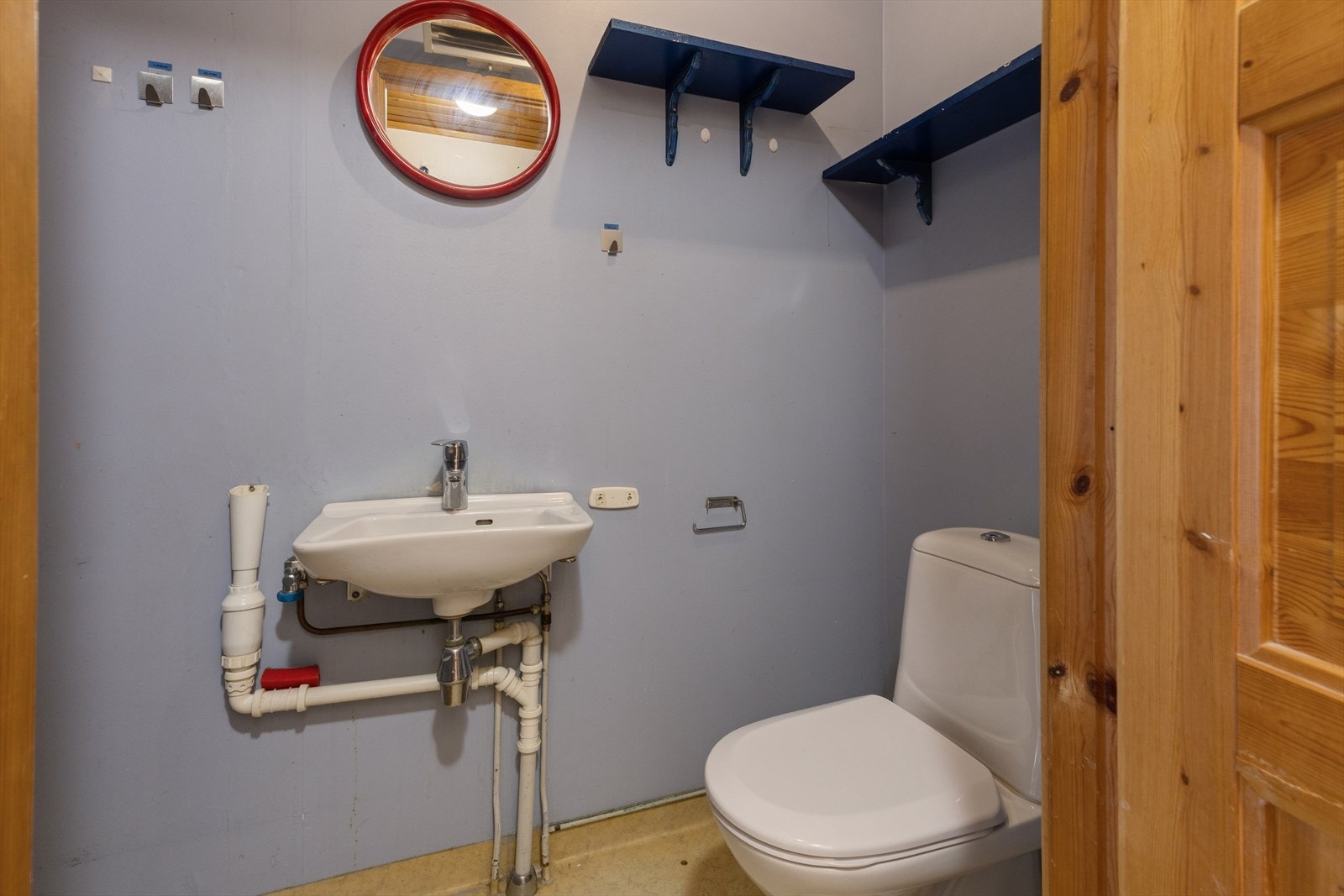 Separat toalettrom med malte veggflater, vinylbelegg på gulv og malt himling. Det er opplegg for vaskemaskin. Galleribilde