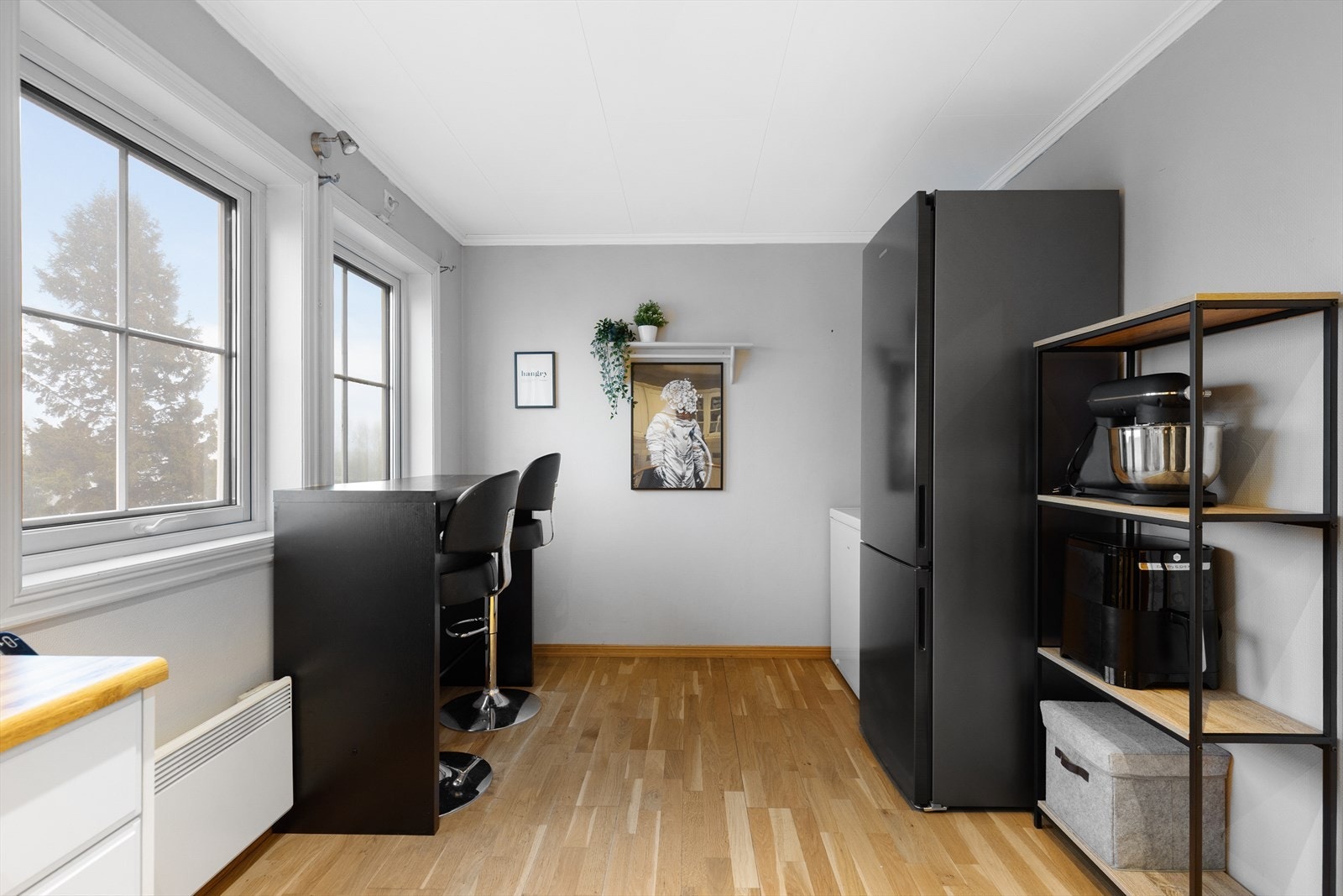 Kjøkkenet har parkett på gulvet og malte veggoverflater, samt belysning over benk og down-light belysning i tak. Galleribilde