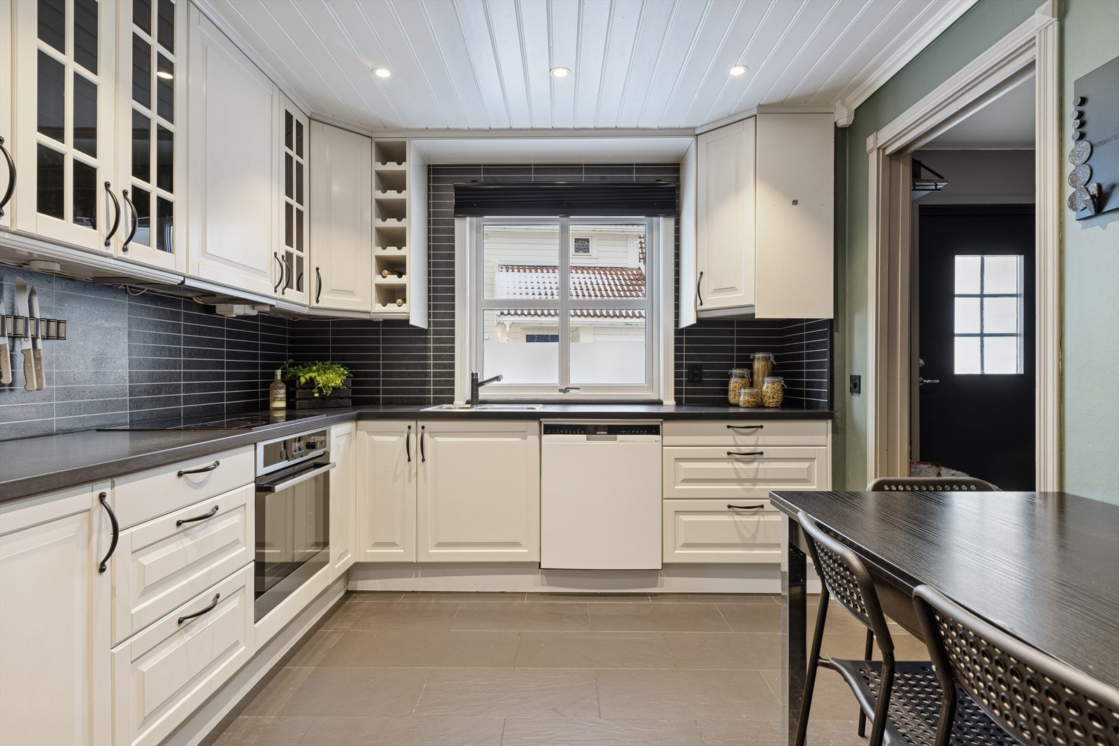 Kjøkkenet er tidløst innredet med hvite, profilerte fronter og mørk benkeplate i laminat. Her man får et stort og godt kjøkken hvor man har rikelig med lagringsplass i skap- og skuffer, samt gode arbeidsflater på benk. Galleribilde