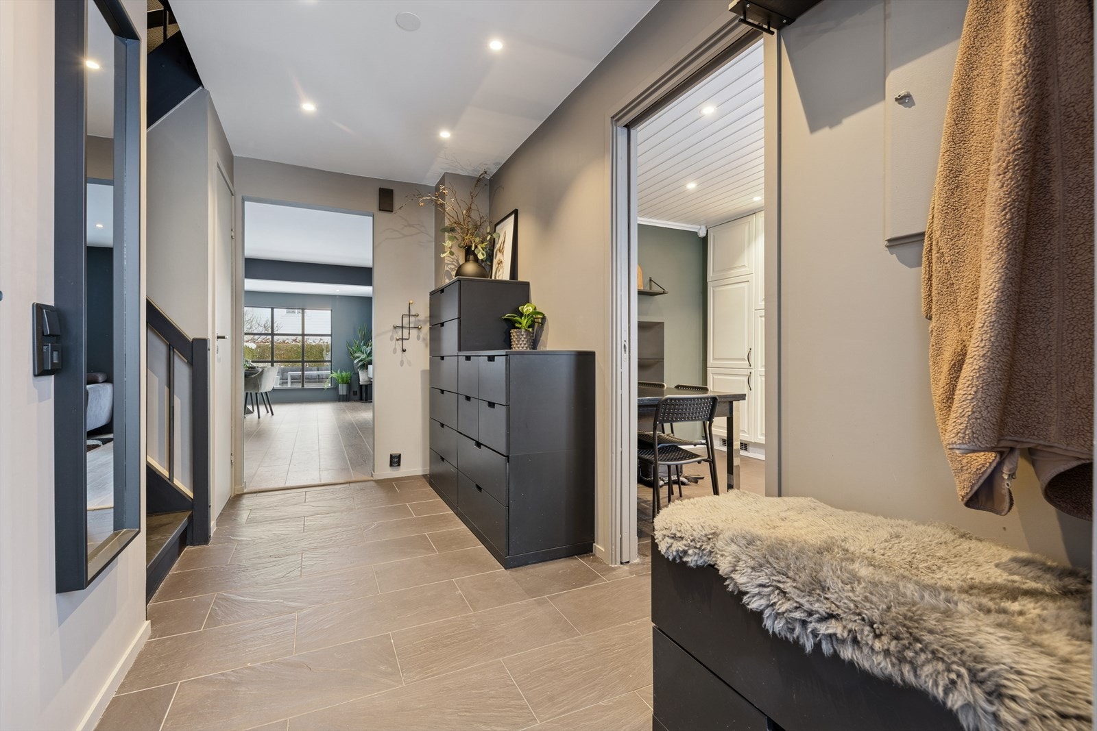 Man ønskes velkommen inn i en romslig gang som er praktisk innredet med flislagt gulv og har god plass til familiens yttertøy og sko. Her får man umiddelbart et godt førsteinntrykk av boligen. Galleribilde