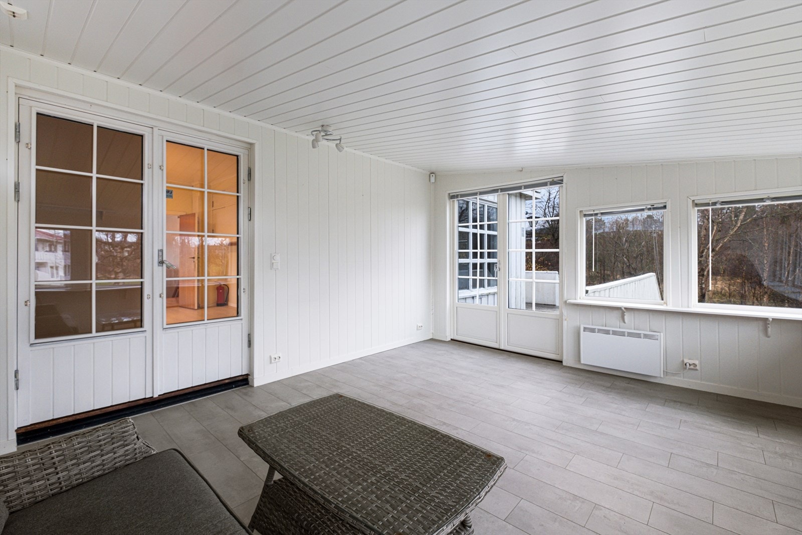 Utestuen har flislagt gulv og panel på veggene, med flere vinduer for lysinnslipp. Galleribilde