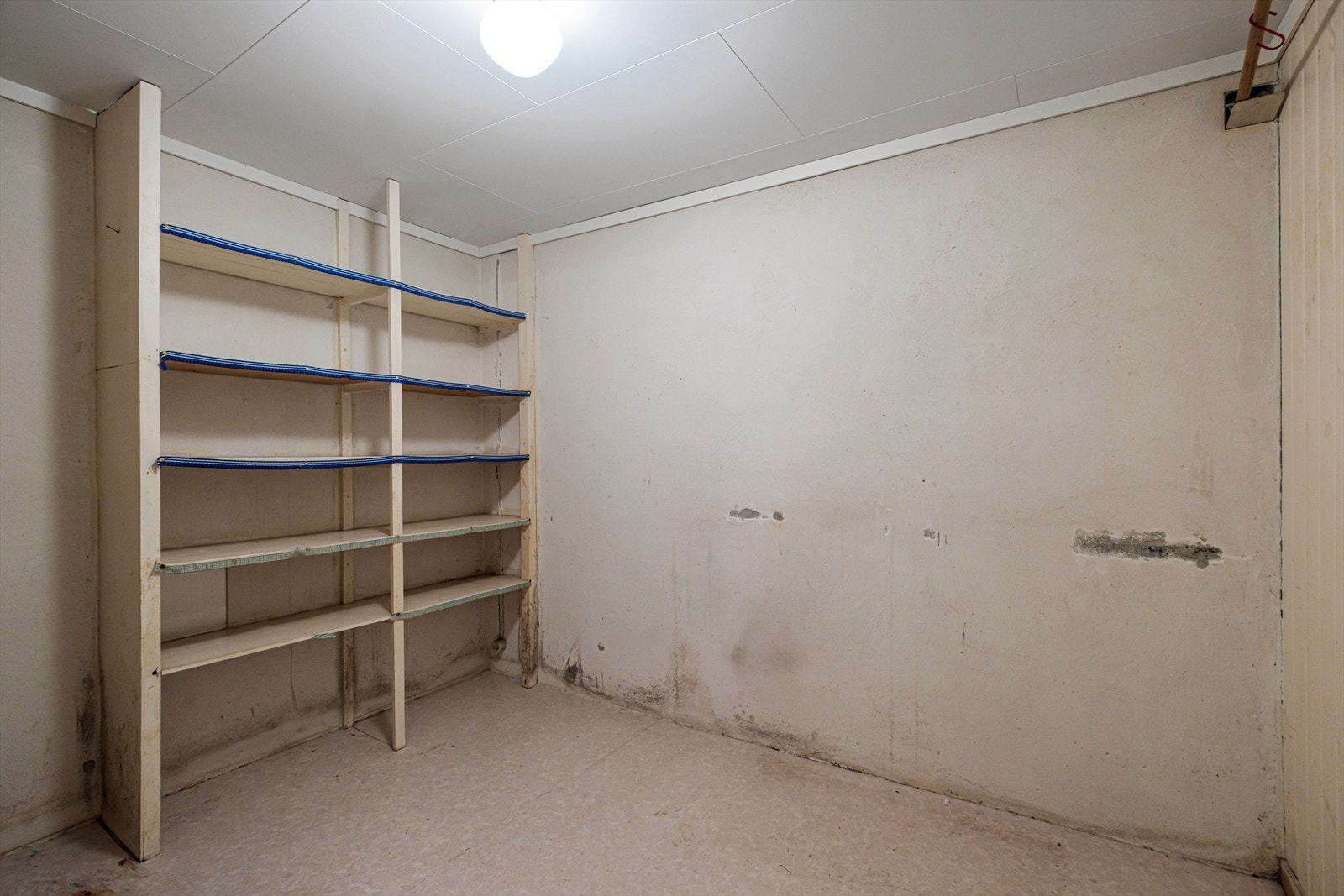 Rommet har enkle hyller for oppbevaring og ubehandlede vegger som gir mulighet for tilpasning. Galleribilde